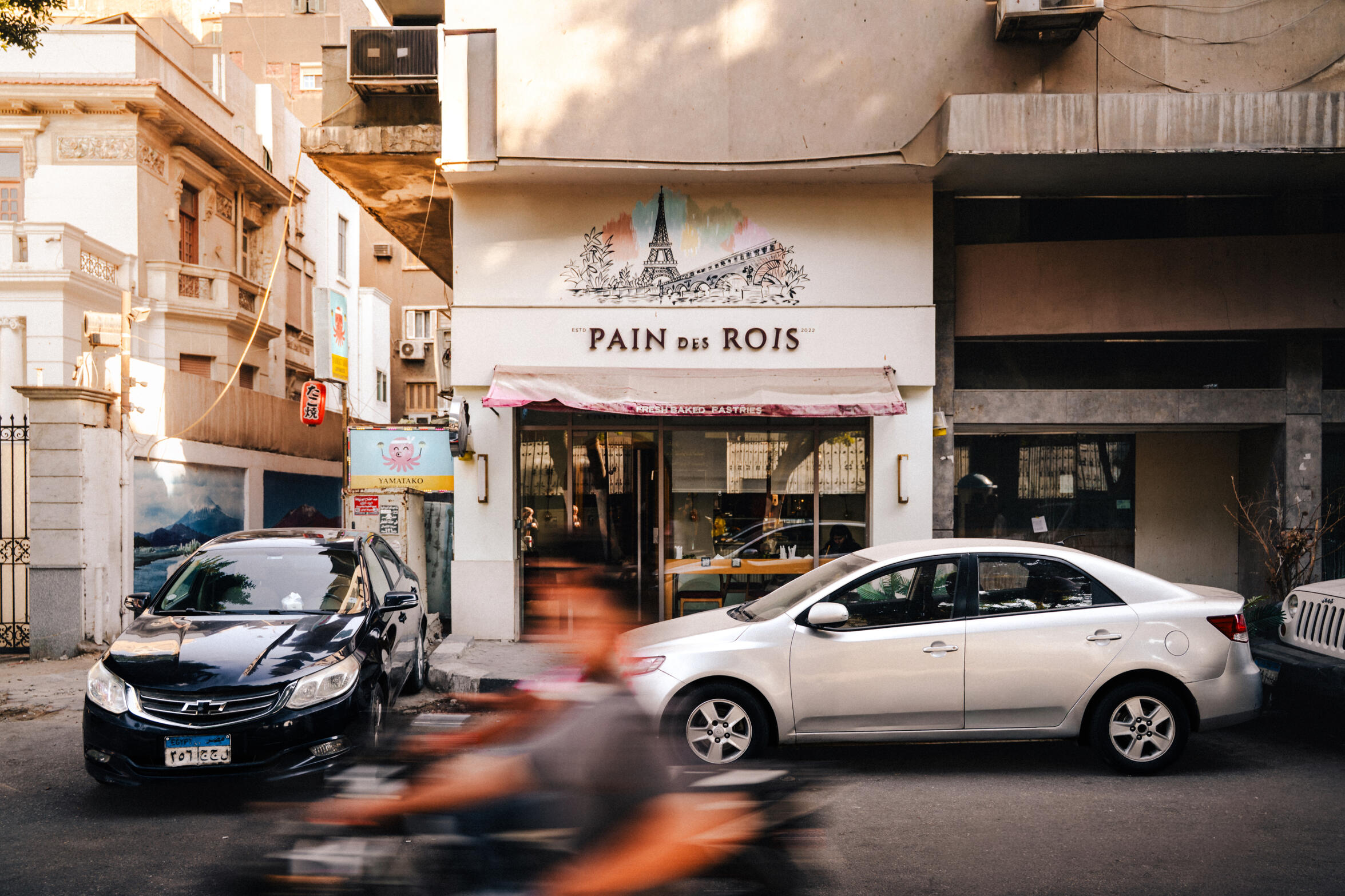 Zamalek Streets — A street shot that showcases one of the cafes in the middle of Cairo, Zamalek district. Multicultural spot as you can spot the Chinese typography on the left of the frame.