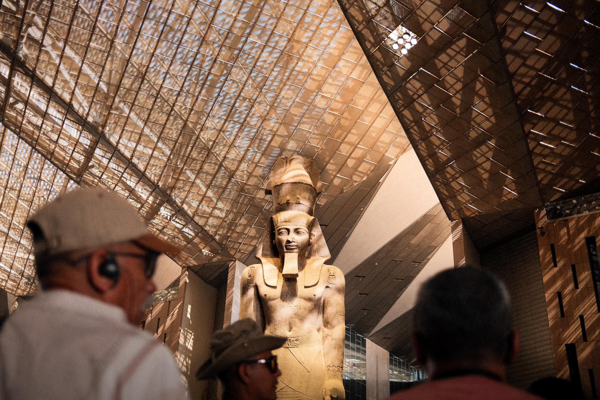 Ramses II — A magical moment at the Grand Egyptian Museum where people are listening carefully to their guide, who shares the history of Ramses II.